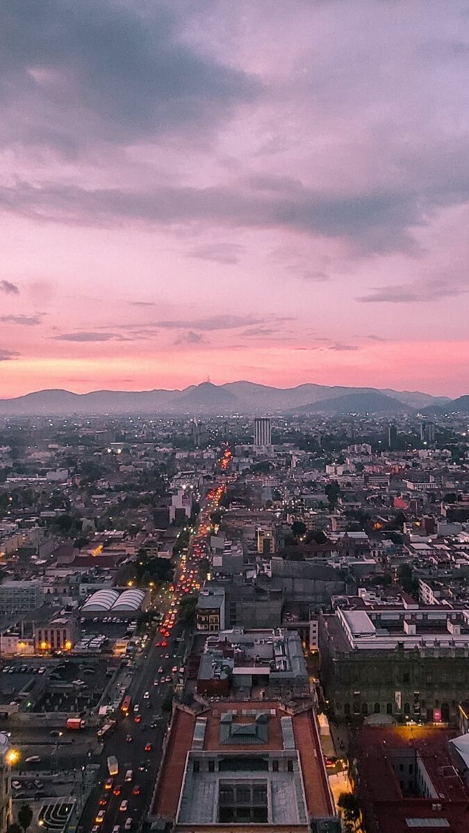Vue panoramique de Mexico City au coucher du soleil avec ciel rose et montagnes en arrière-plan