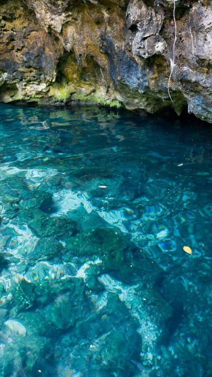 Cénote souterrain aux eaux bleu profond avec stalactites et formations rocheuses