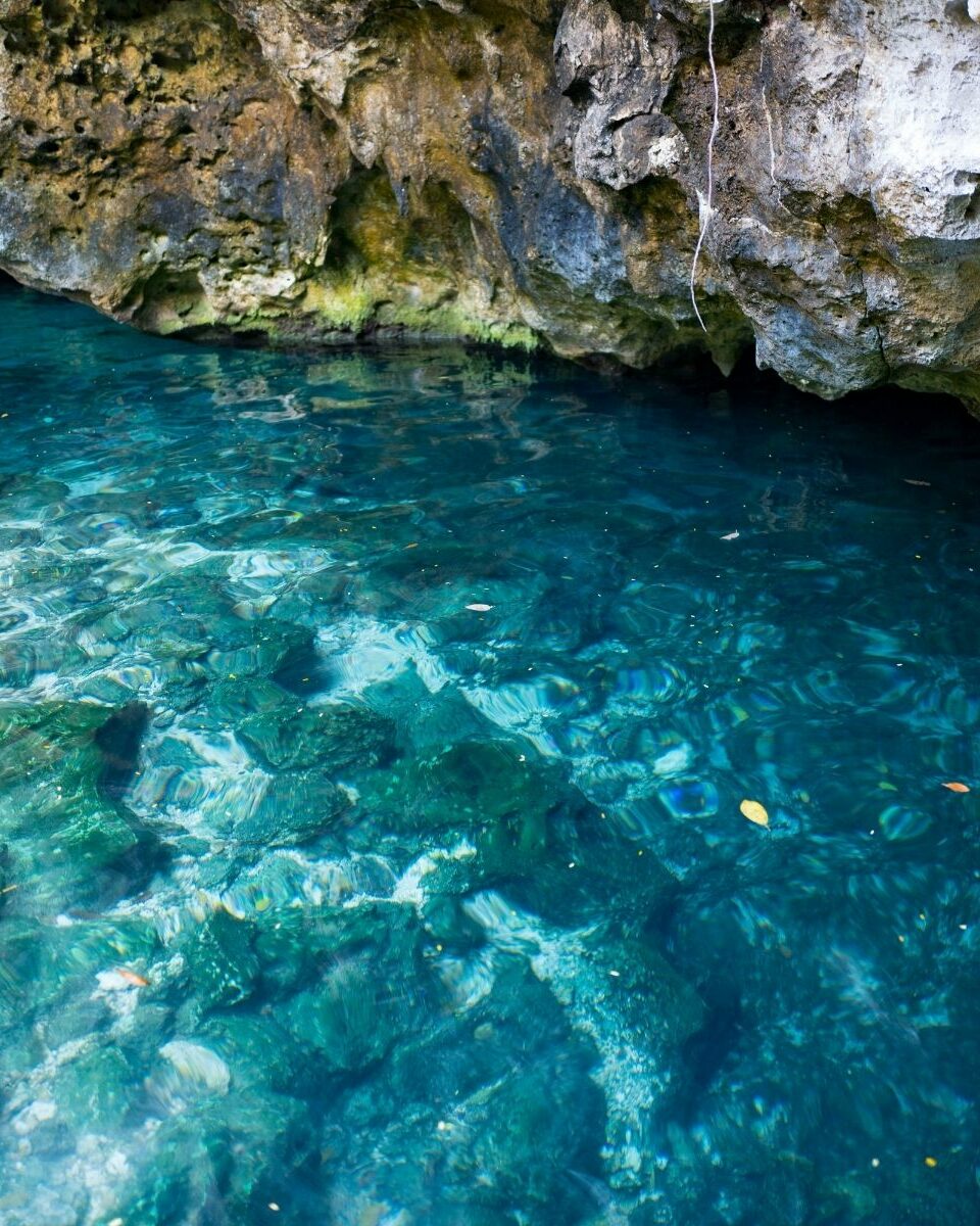 Cénote souterrain aux eaux bleu profond avec stalactites et formations rocheuses