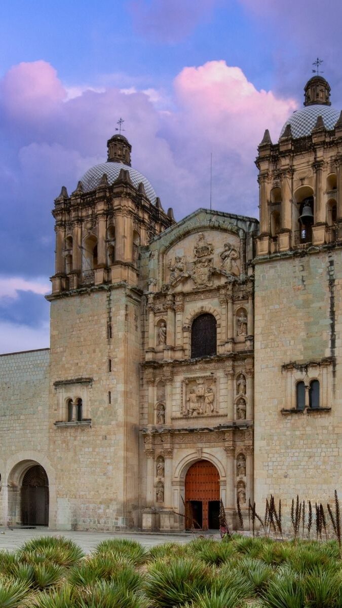 Église Santo Domingo de Guzmán à Oaxaca avec sa façade baroque en pierre dorée au crépuscule