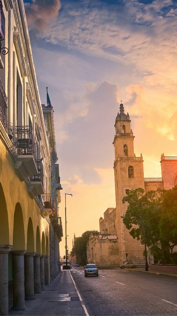 Rue coloniale de Mérida avec arcades et cathédrale au coucher du soleil