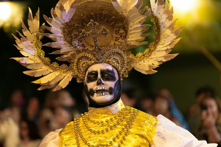 Homme maquillé en Catrina dorée avec coiffe lors des célébrations du Día de Muertos au Mexique