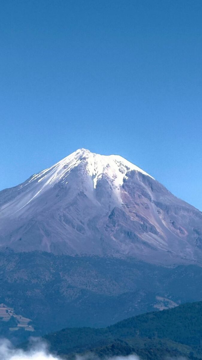 Vue majestueuse du Pico de Orizaba au sommet enneigé sous un ciel bleu limpide