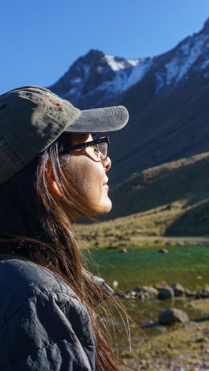 Randonneuse contemplant un lac turquoise au pied de l'Iztaccíhuatl enneigé