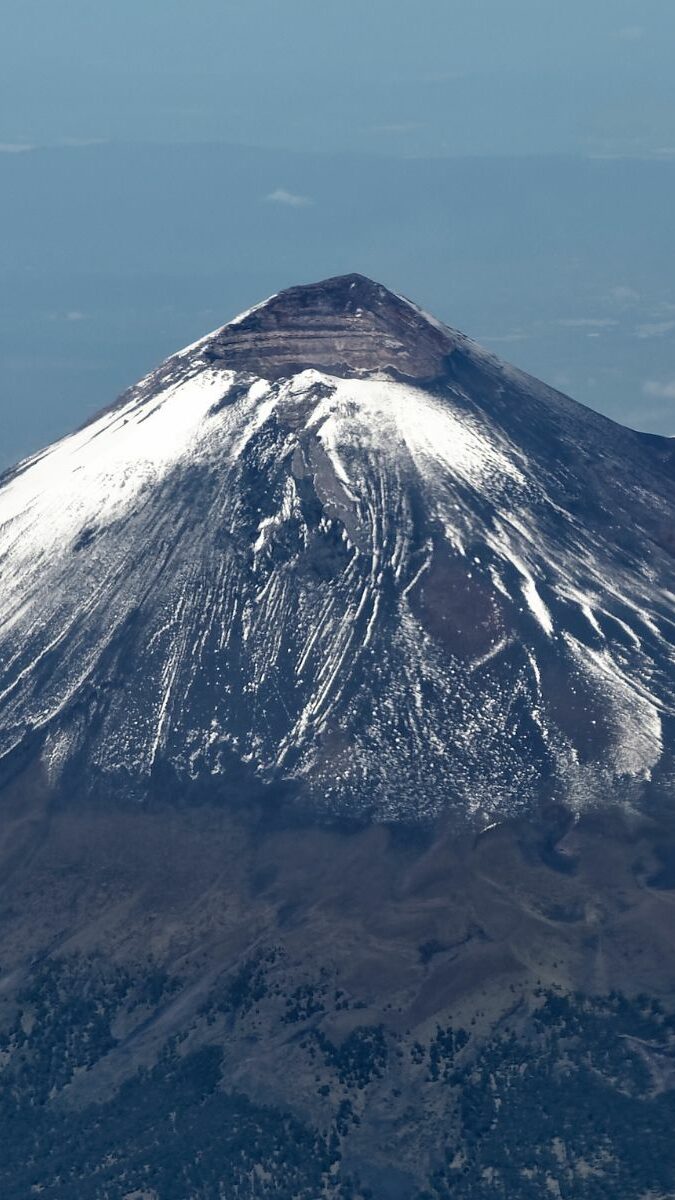 Vue aérienne du Popocatépetl enneigé entouré de nuages, volcan actif du Mexique