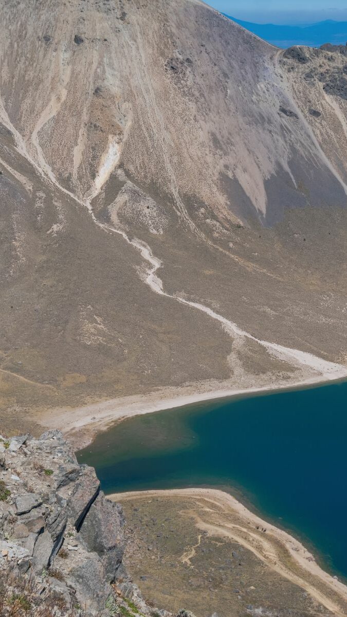 Randonneur avec sac à dos surplombant le lac du cratère du Nevado de Toluca