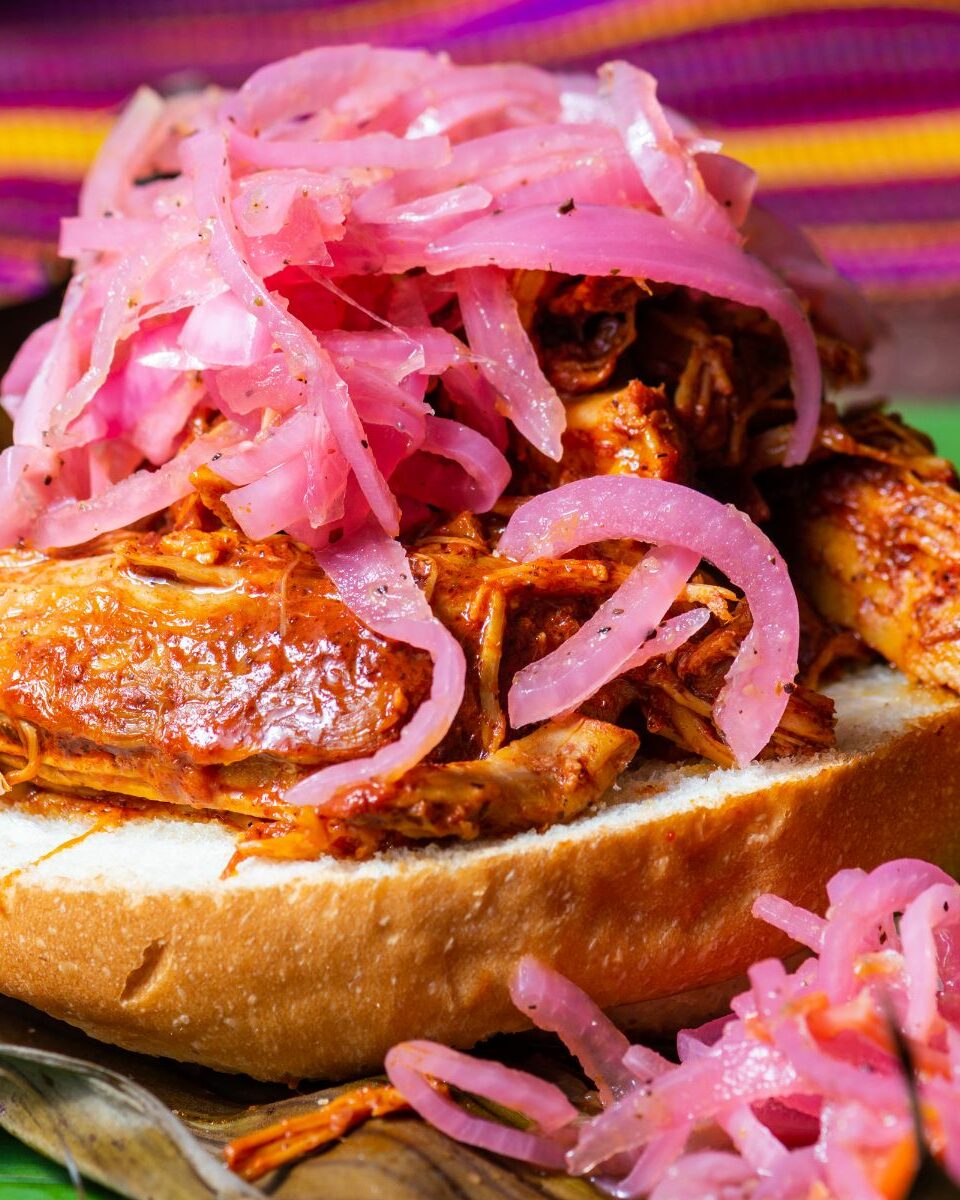 Cochinita pibil en torta avec oignons rouges marinés, spécialité du Yucatán