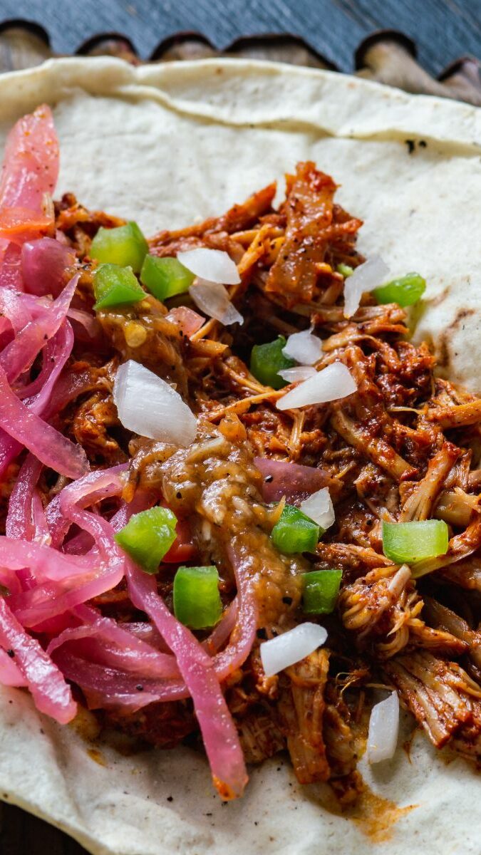 Taco de cochinita pibil avec oignons rouges, piment habanero et citron vert