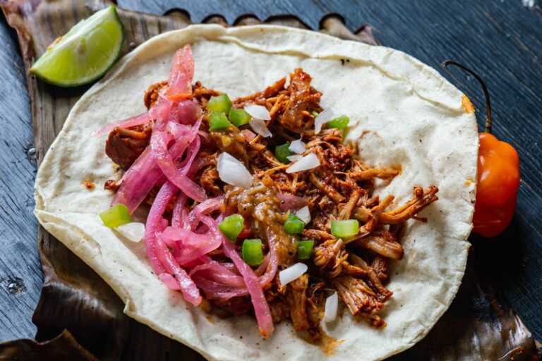 Taco de cochinita pibil avec oignons rouges, piment habanero et citron vert