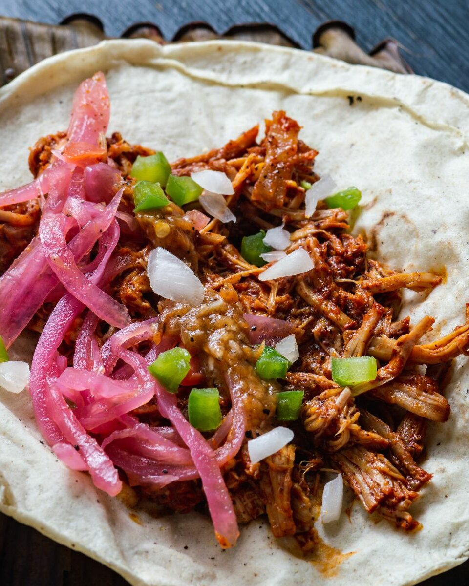 Taco de cochinita pibil avec oignons rouges, piment habanero et citron vert