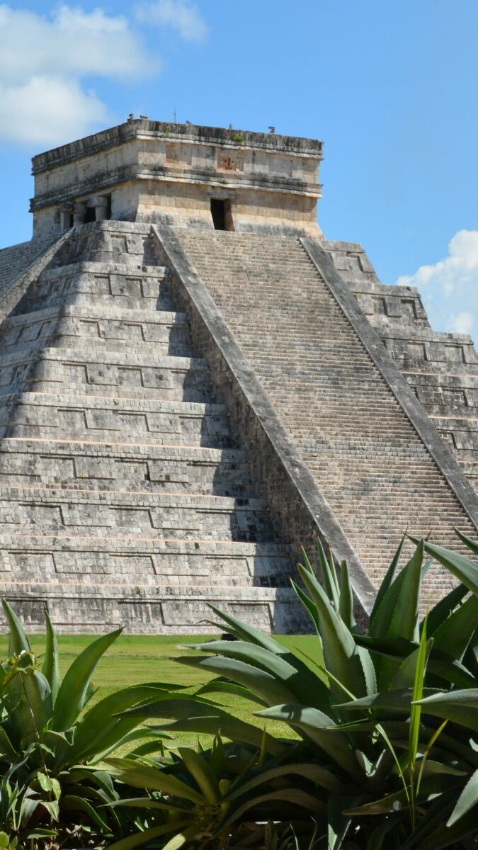 Pyramide de Kukulcán à Chichén Itzá entourée de végétation tropicale sous un ciel bleu